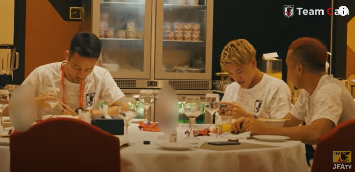 食事している堂安律選手と長友佑都選手、吉田麻也選手の写真